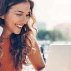 Frau mit Kaffeetasse und Laptop
